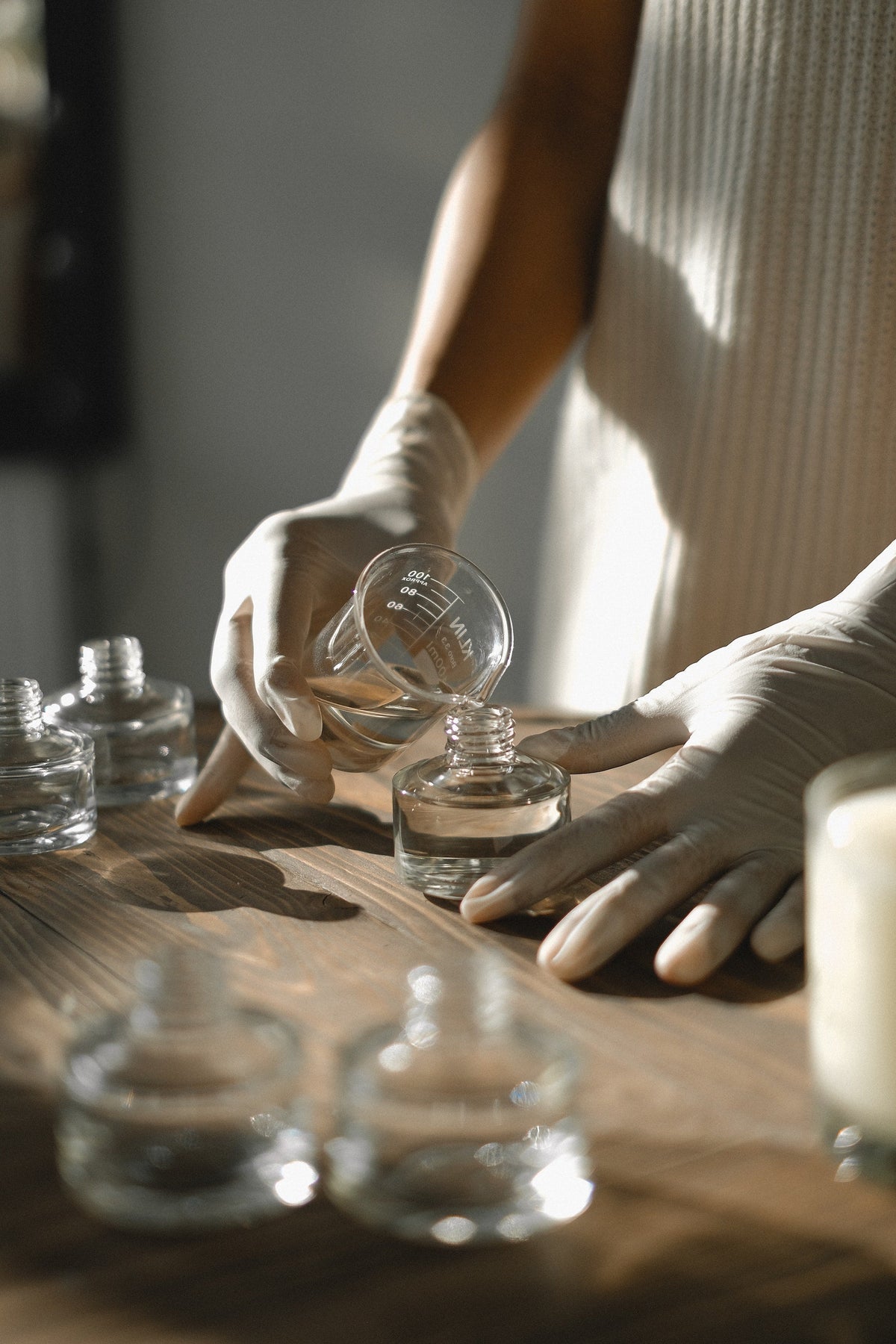 Rustic Strength, image of clear liquid being poured from glass measuring cup into a glass jar