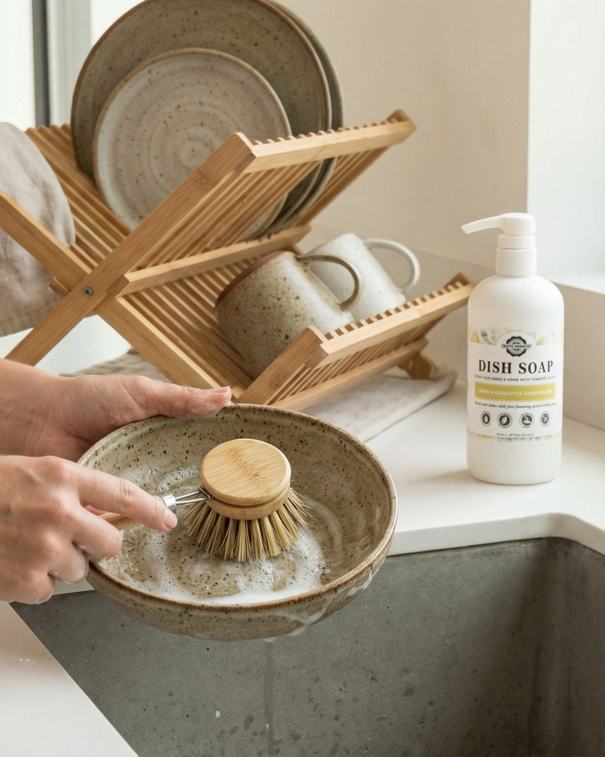 Person washing dishes using lemon eucalyptus dish soap.