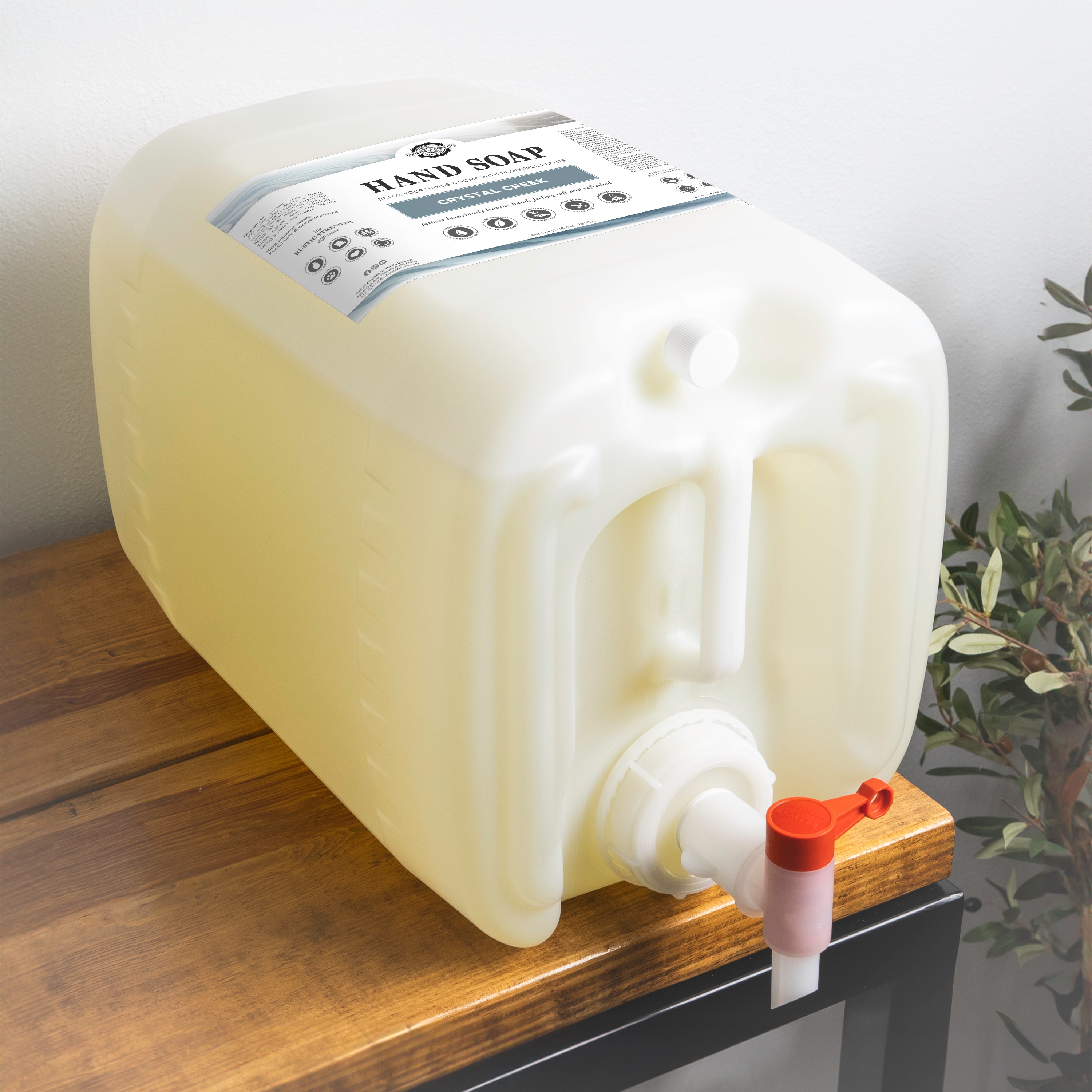 5 gallon container of Crystal Creek scented had soap on a wooden table