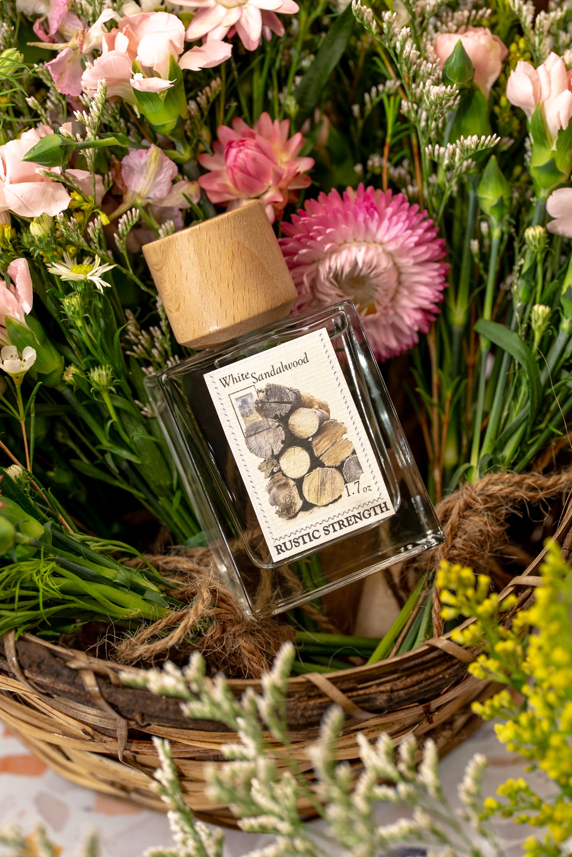 White Sandalwood perfume in a 1.7 ounce glass bottle sitting in a basket of flowers.