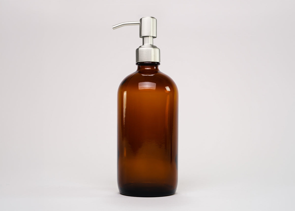 Rustic Strength, 16oz Amber Glass bottle with stainless steel pump cap on a neutral background
