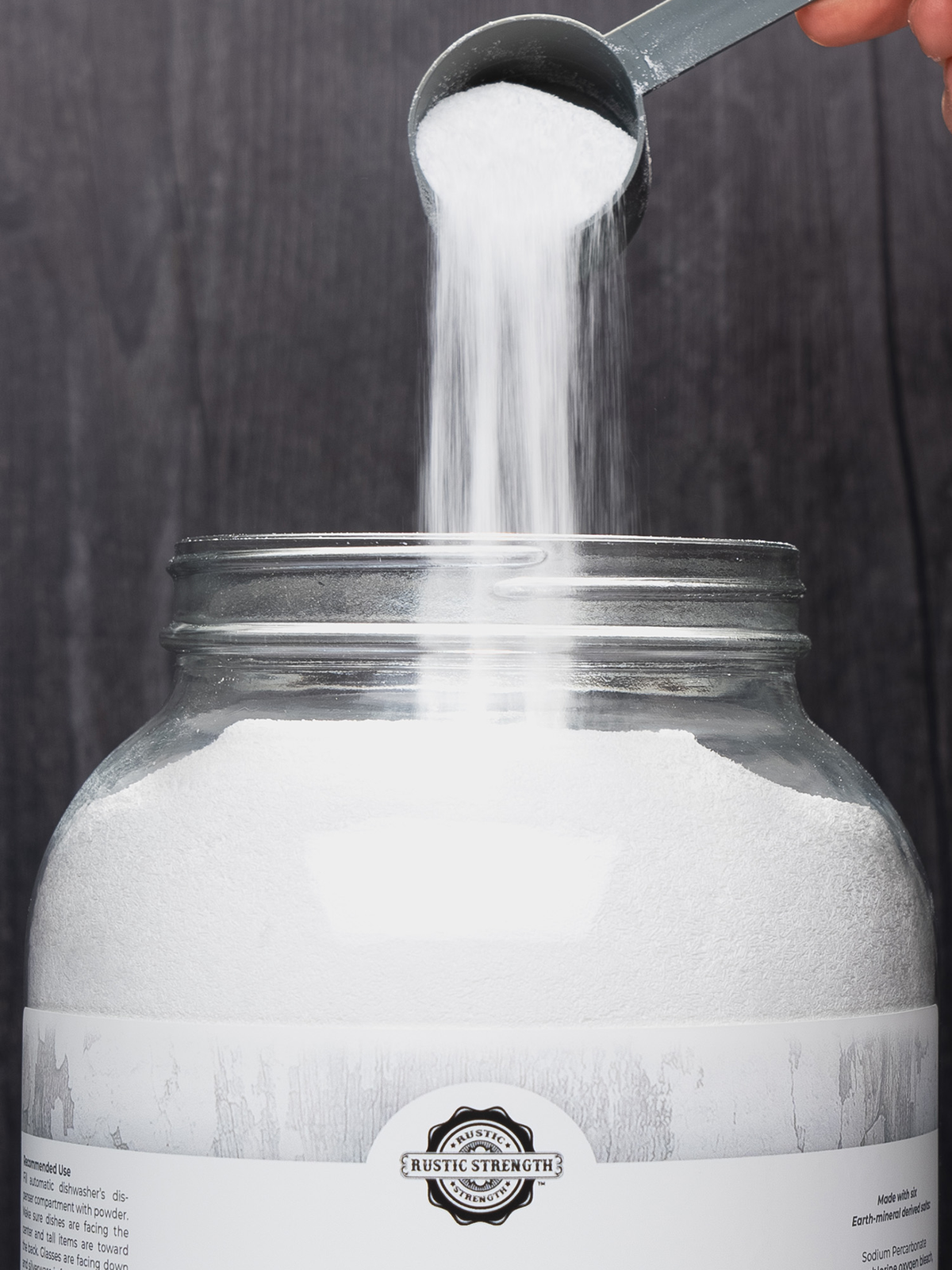 Rustic Strength - White powder being poured from a scoop into a Rustic Strength glass jar