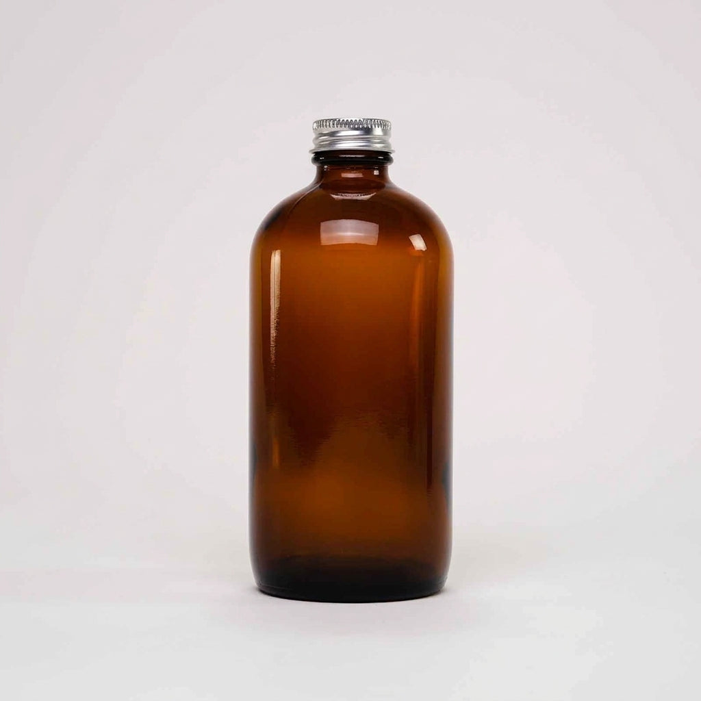 Rustic Strength, An empty 16oz amber glass bottle with a silver metal screw cap, centered against a plain light gray background.